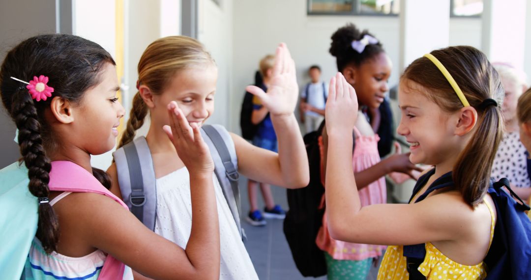 Excited Schoolchildren Giving High Fives in Corridor - Free Images, Stock Photos and Pictures on Pikwizard.com