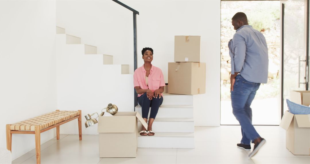 Joyous Couple Moving Into New Home With Boxes Amidst Relocation