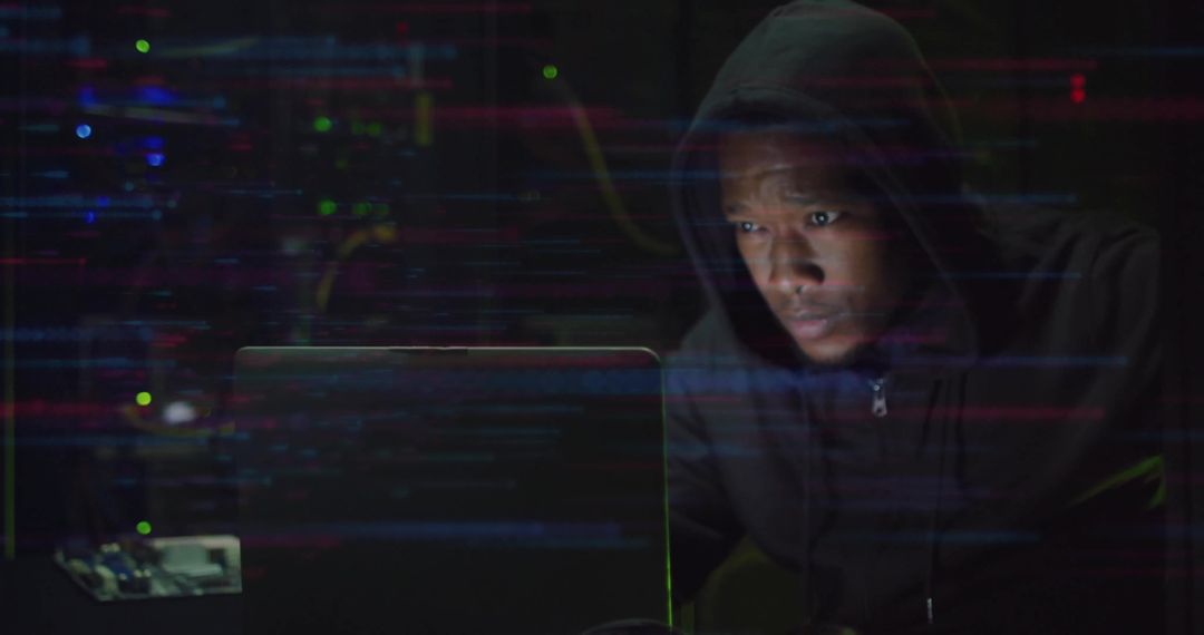 Modern Hacker Focused on Laptop in Dimly Lit Server Room
