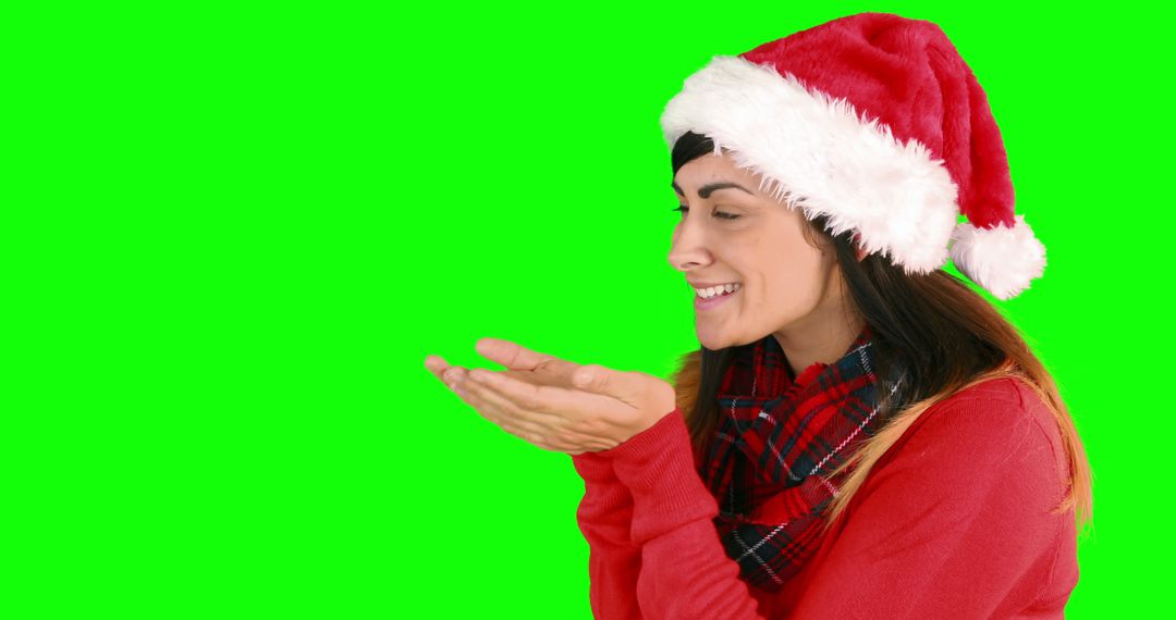 Woman With Santa Hat Blowing a Kiss on Green Background - Free Images, Stock Photos and Pictures on Pikwizard.com