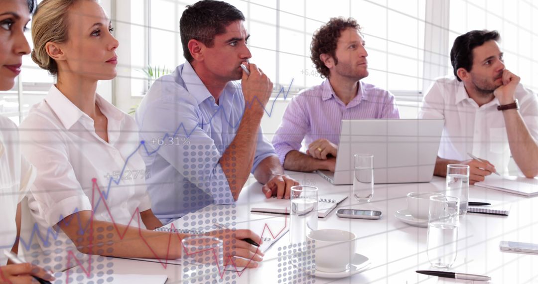 Team Analyzing Financial Graphs During Office Meeting