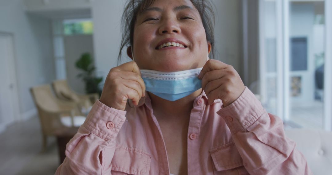 Portrait of asian female patient wearing face mask, lowering mask and smiling to camera - Free Images, Stock Photos and Pictures on Pikwizard.com