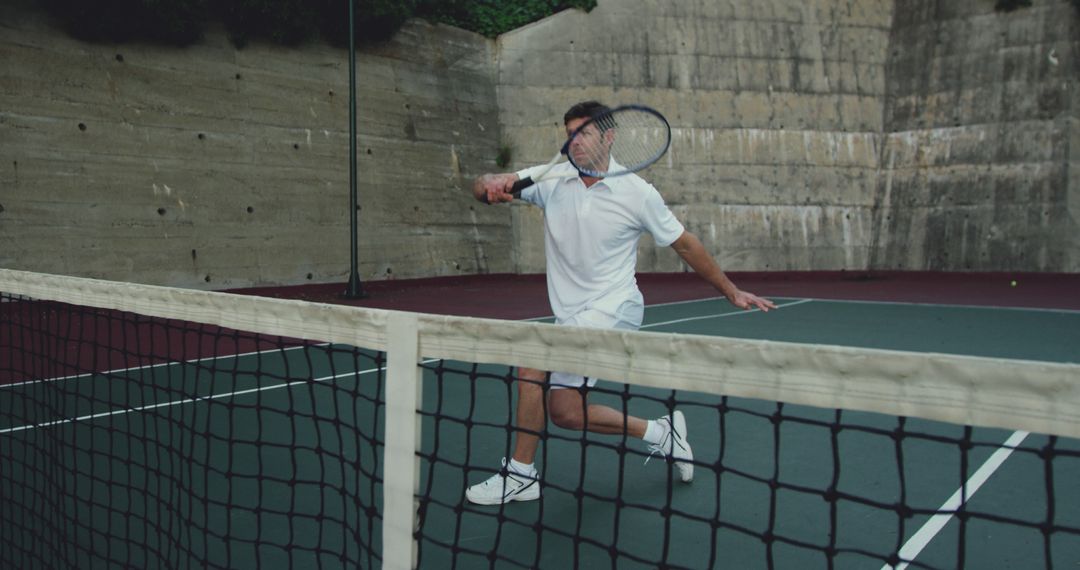 Man Wearing White While Playing Intense Tennis Match - Free Images, Stock Photos and Pictures on Pikwizard.com