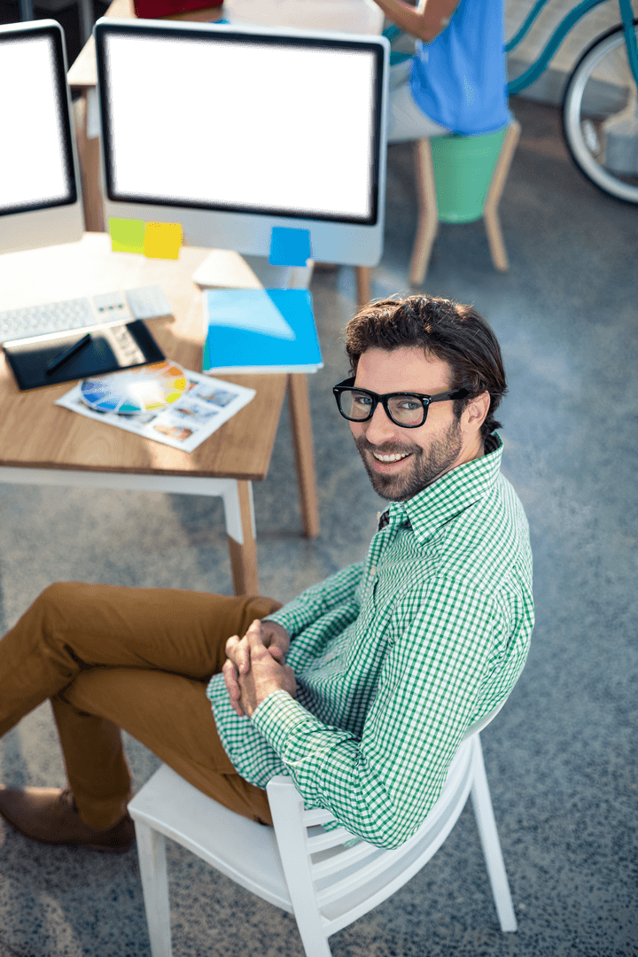 Smiling Graphic Designer in Modern Office Workspace with Transparent Elements