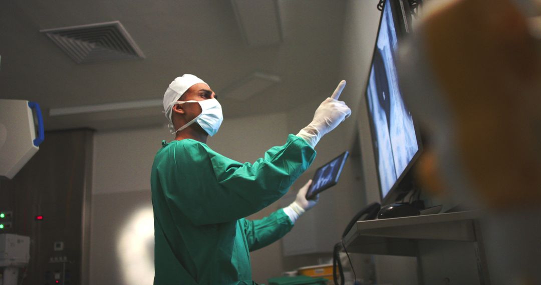 Surgeon Examining Medical X-Rays on Monitor in Surgical Room - Free Images, Stock Photos and Pictures on Pikwizard.com