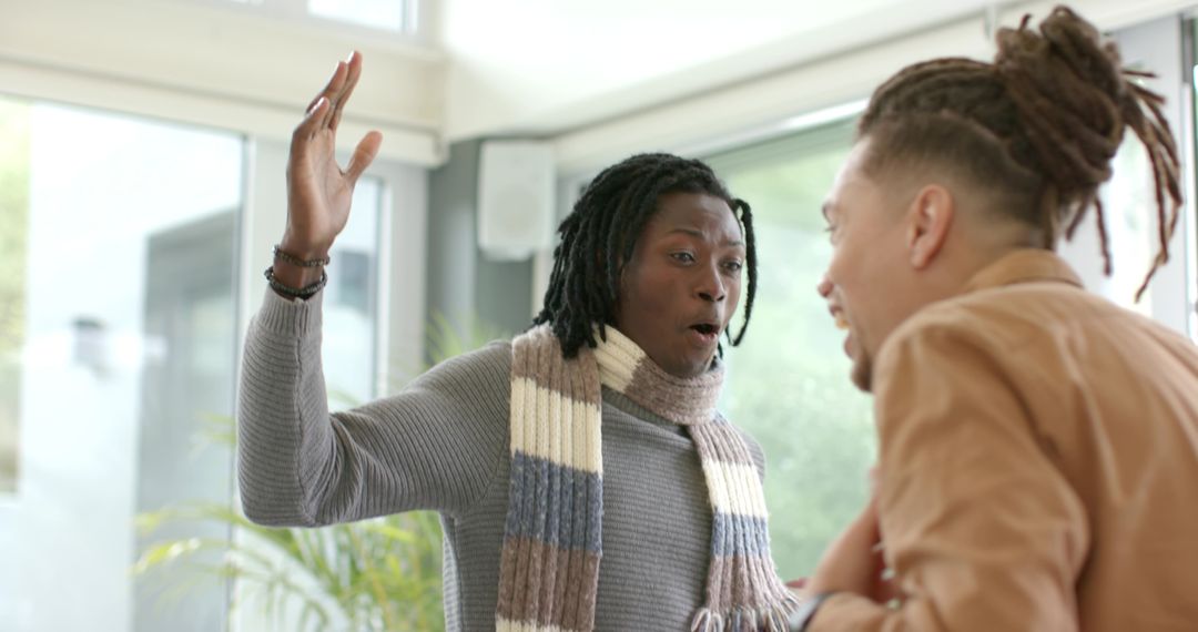 Expressing surprise and excitement during friendly conversation in sunlit modern living room