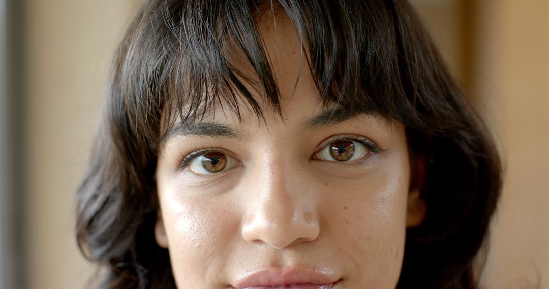 Serene Woman with Dark Hair and Freckles in Soft Light