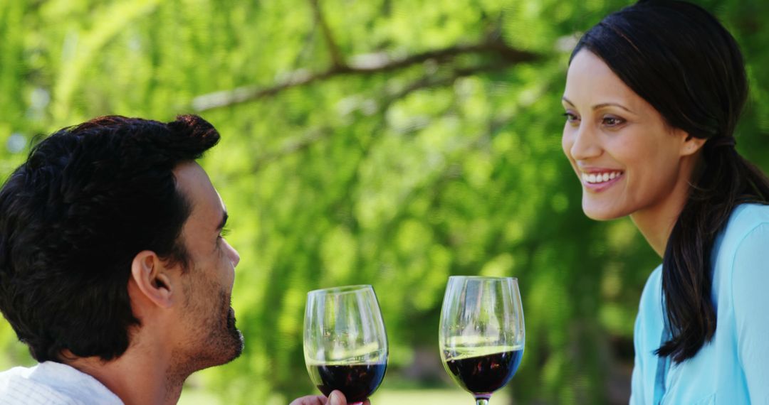 Couple Enjoying Conversation with Wine in a Sunny Park