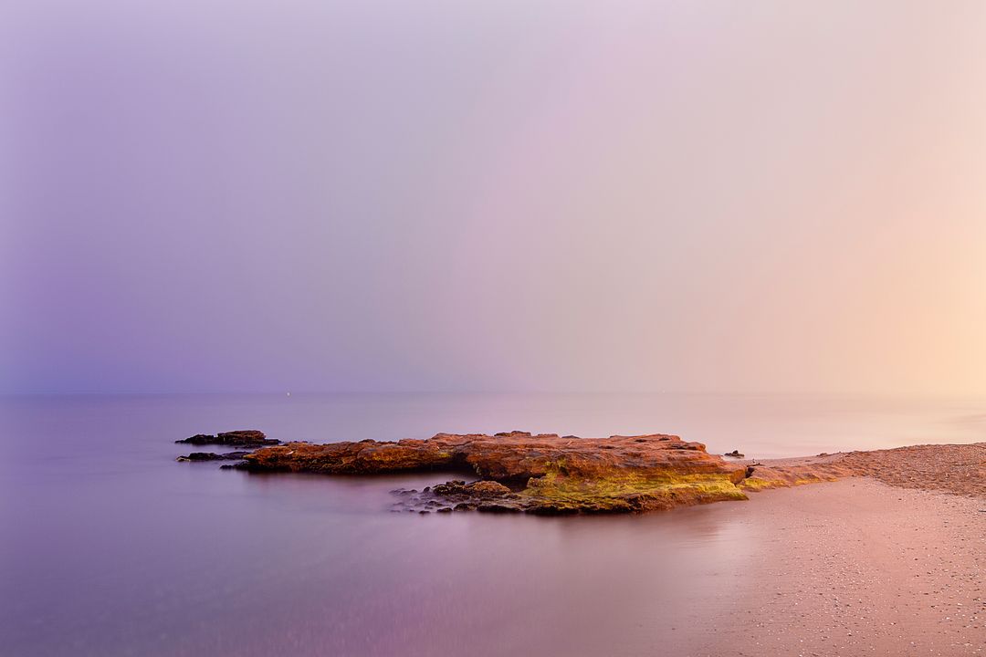 Serene Sunrise Over Tranquil Rocky Beach - Free Images, Stock Photos and Pictures on Pikwizard.com