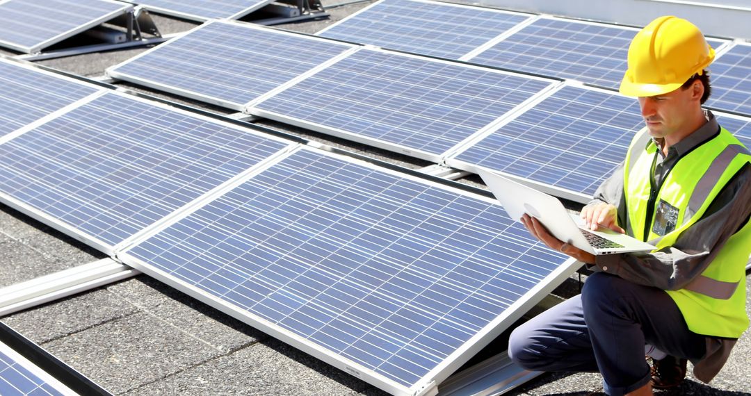 Engineer inspecting solar panels with laptop on rooftop - Free Images, Stock Photos and Pictures on Pikwizard.com