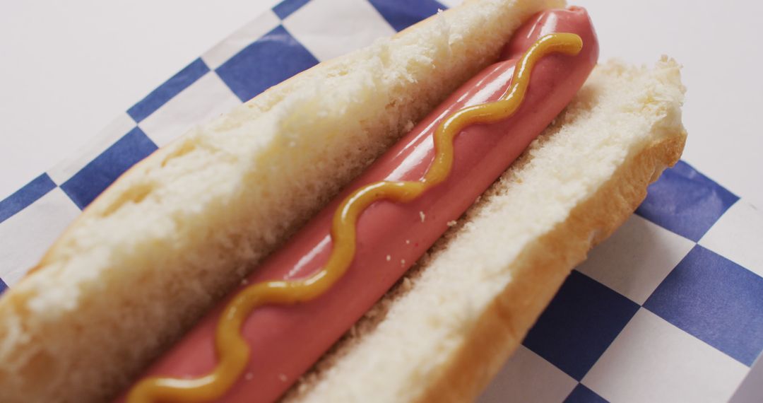 Image of hot dog with mustard on a white surface - Free Images, Stock Photos and Pictures on Pikwizard.com