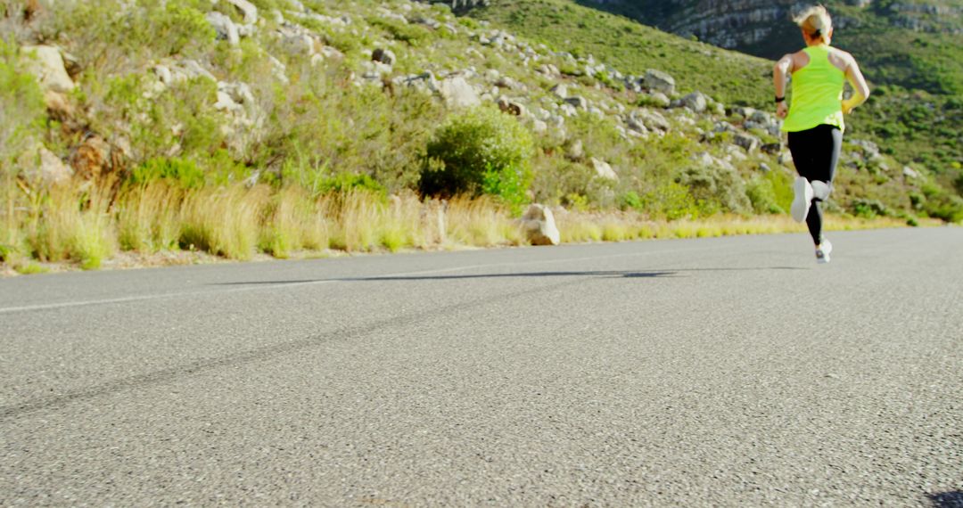 Athlete Running on Mountain Road in Bright Activewear - Free Images, Stock Photos and Pictures on Pikwizard.com