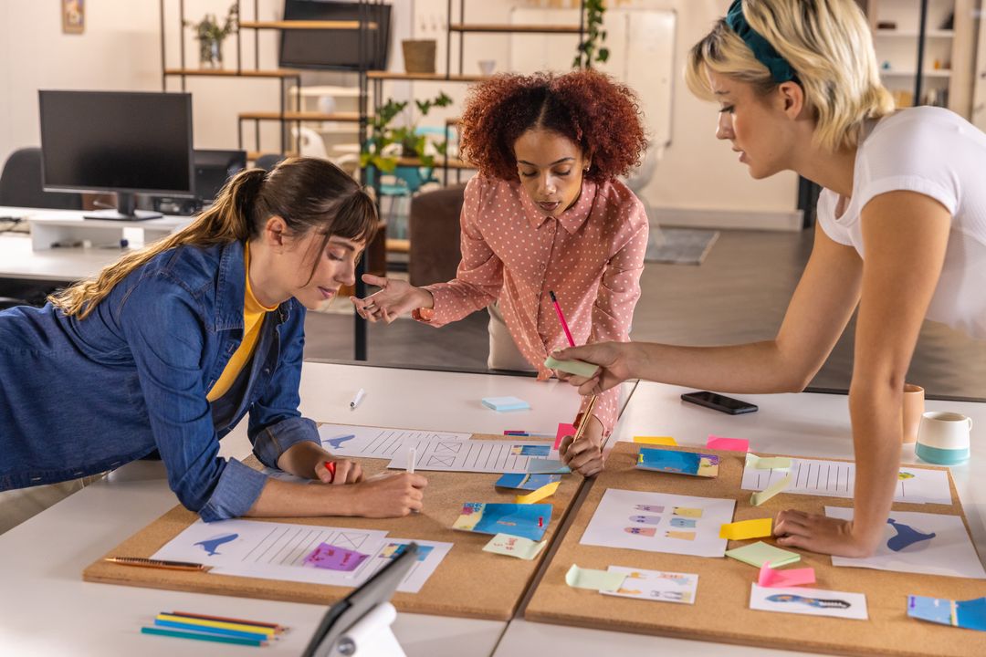Diverse Female Team Brainstorming on Creative Project in Modern Office