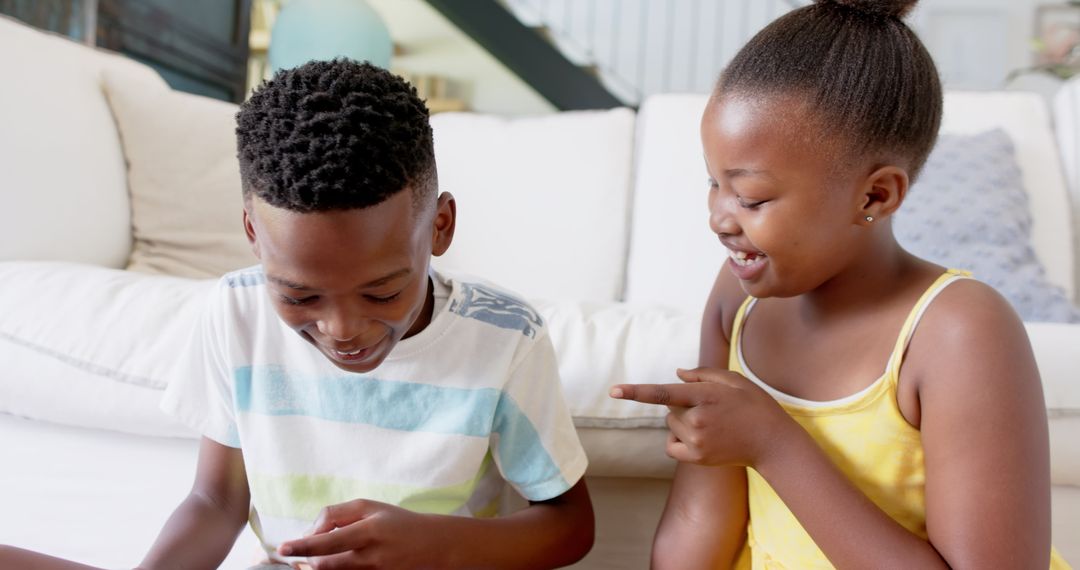 Smiling Siblings Enjoying Tablet Together at Home