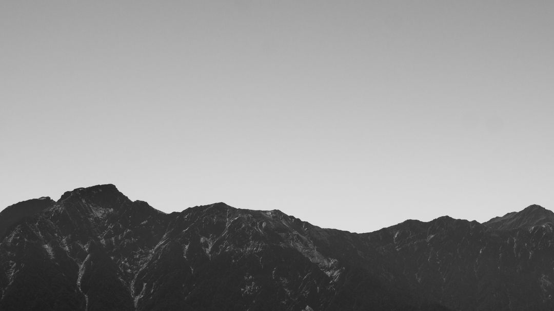 Black and white mountain range landscape against clear sky