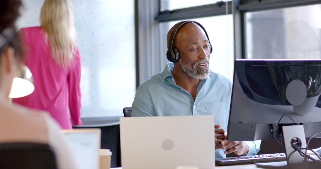 Focused Professional in Modern Office Using Headphones and Computer