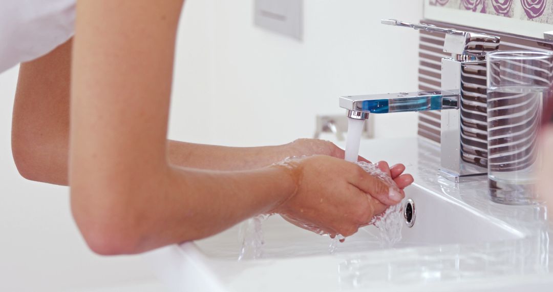 Person Washing Hands in Modern Bathroom Sink for Hygiene - Free Images, Stock Photos and Pictures on Pikwizard.com