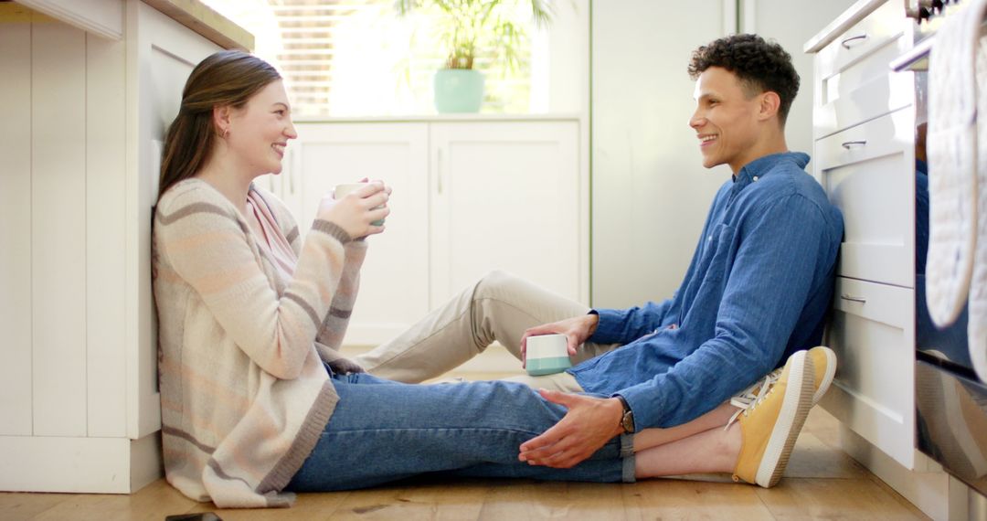 Happy Couple Relaxing with Coffee on Kitchen Floor