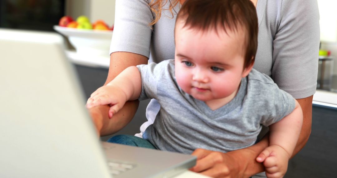 Mother Working on Laptop with Baby on Lap, Balancing Work and Parenting - Free Images, Stock Photos and Pictures on Pikwizard.com