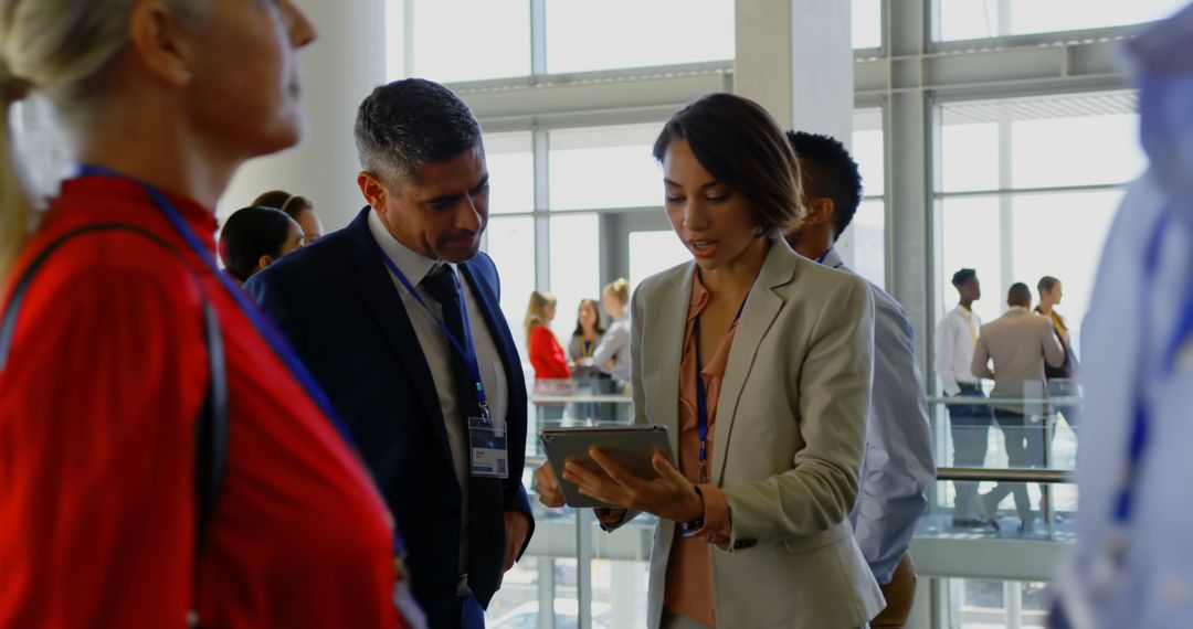 Business Professionals Collaborating with Digital Tablet in Modern Office Lobby
