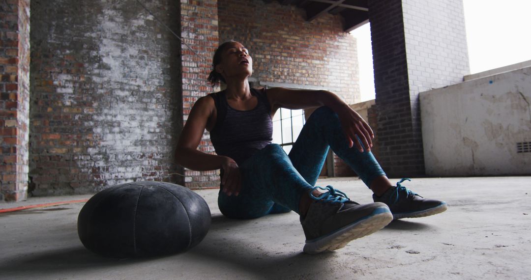 Exhausted Woman Resting After Intense Workout in Industrial Gym - Free Images, Stock Photos and Pictures on Pikwizard.com