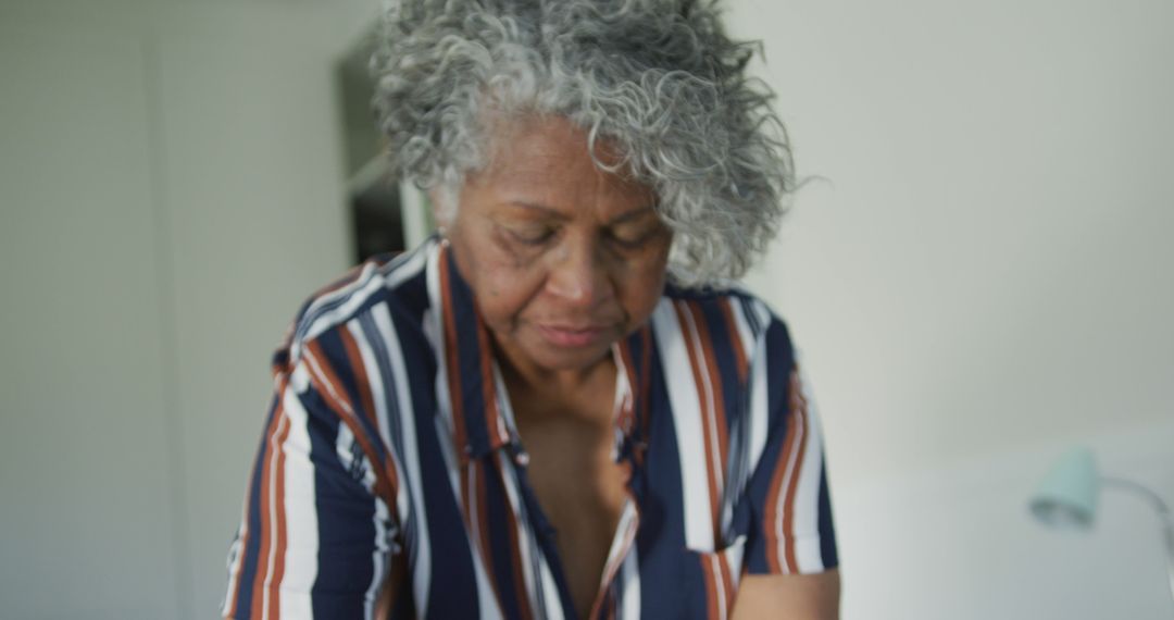 Senior Woman With Curly Gray Hair Wearing Striped Shirt Indoors - Free Images, Stock Photos and Pictures on Pikwizard.com