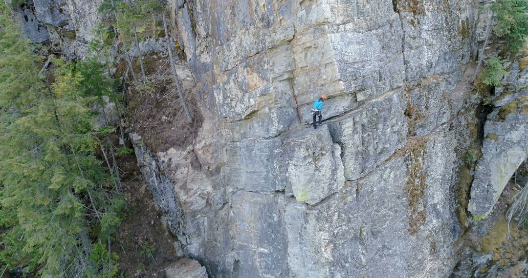 A climber ascends a steep cliff in a rugged outdoor setting - Free Images, Stock Photos and Pictures on Pikwizard.com