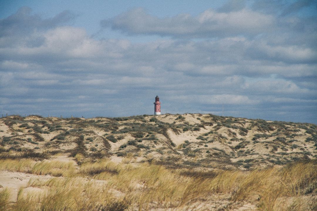 Secluded Lighthouse in Scenic Sand Dunes on a Cloudy Day - Free Images, Stock Photos and Pictures on Pikwizard.com