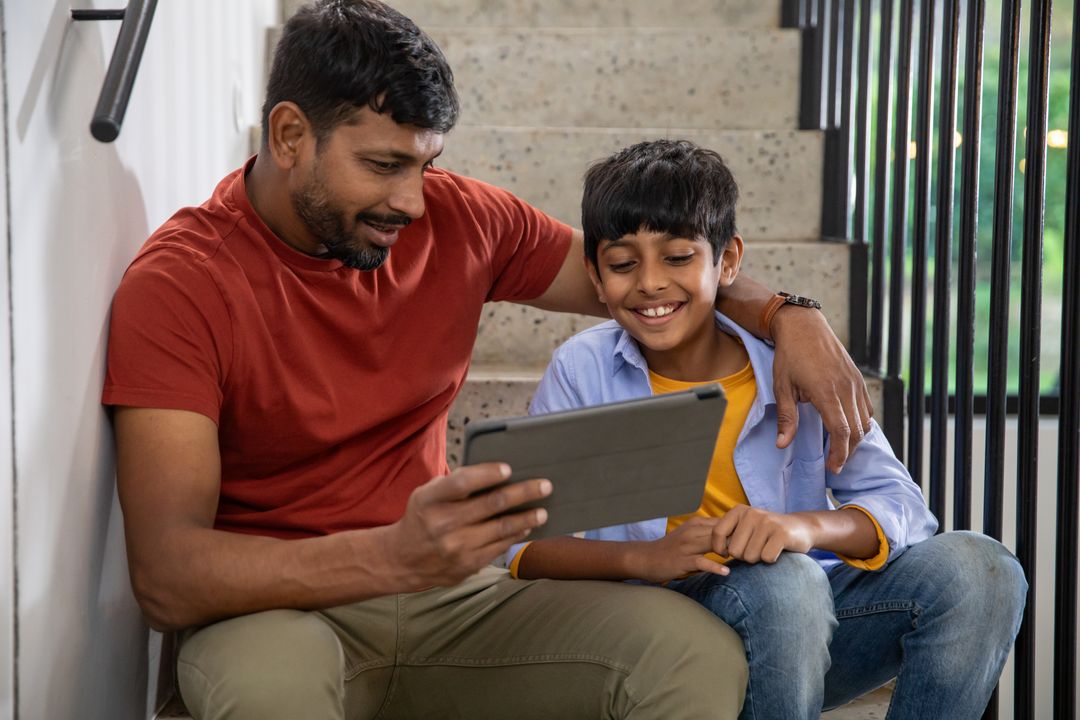Father and Son Enjoying Time Together on Tablet at Home