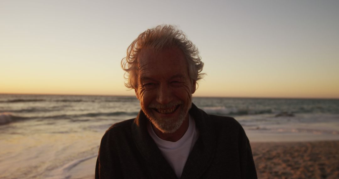 Happy Senior Man Smiling On Beach at Sunset - Free Images, Stock Photos and Pictures on Pikwizard.com