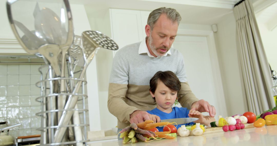 Father Helping Son Cutting Vegetables in Modern Kitchen - Free Images, Stock Photos and Pictures on Pikwizard.com