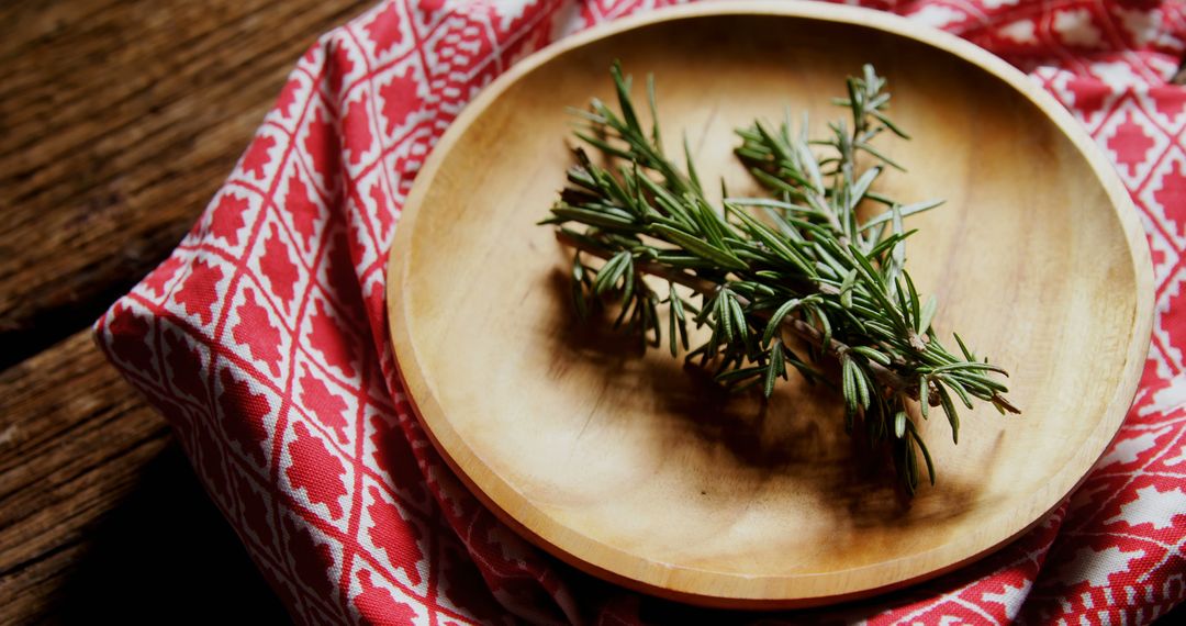 Rosemary Sprigs on Wooden Plate with Rustic Red Decorative Cloth - Free Images, Stock Photos and Pictures on Pikwizard.com