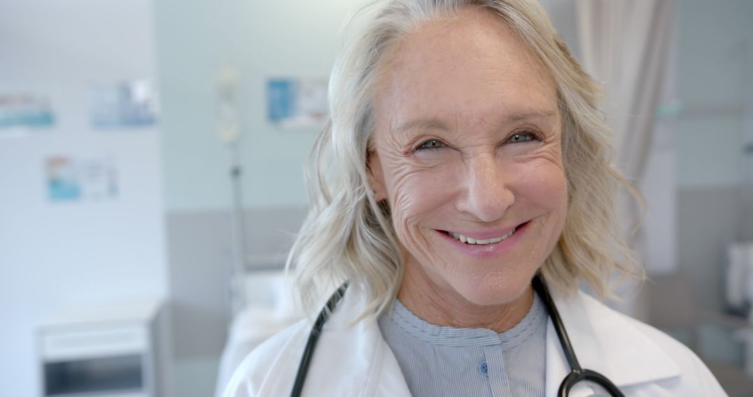 Friendly Senior Female Doctor Smiling in Hospital Setting - Free Images, Stock Photos and Pictures on Pikwizard.com