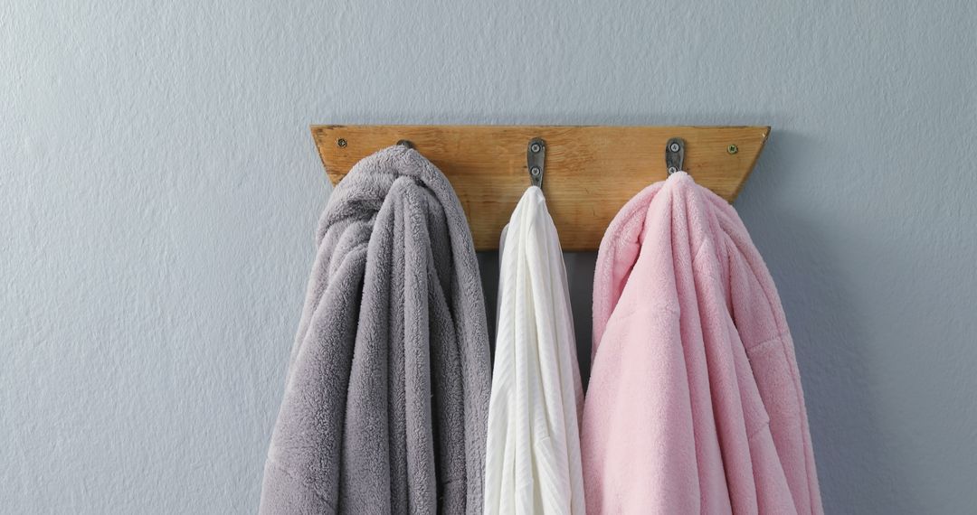 Three Towels Hanging on Wooden Rack in Bathroom Against Gray Wall - Free Images, Stock Photos and Pictures on Pikwizard.com