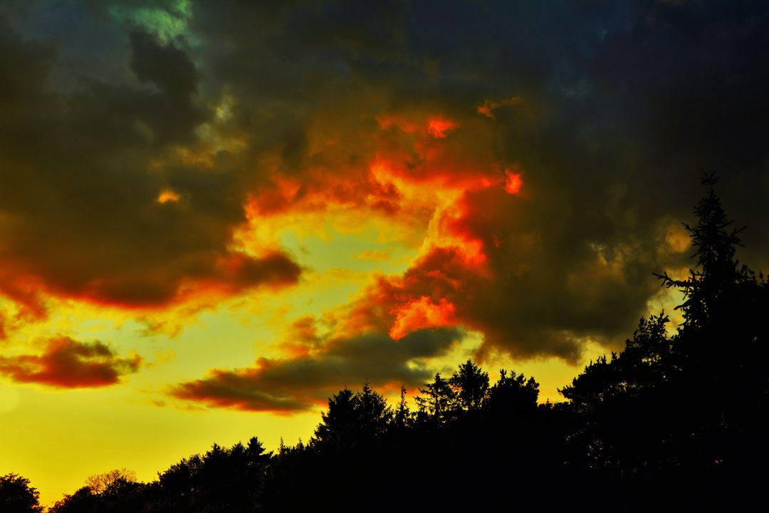 Vibrant Sunset Cloudscape with Silhouetted Trees - Free Images, Stock Photos and Pictures on Pikwizard.com
