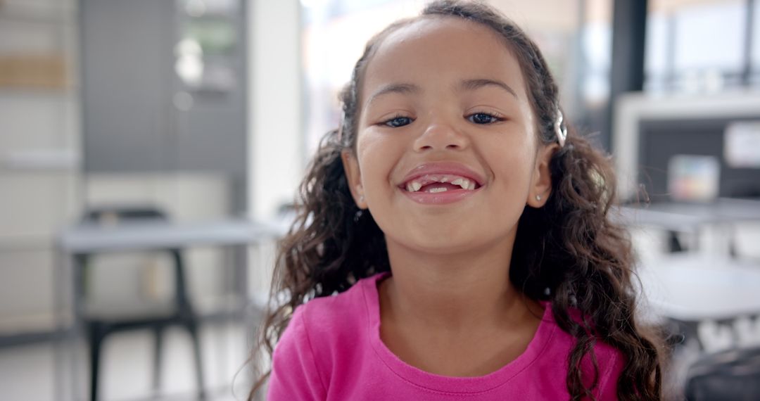Smiling Young Girl with Missing Teeth in Classroom Environment