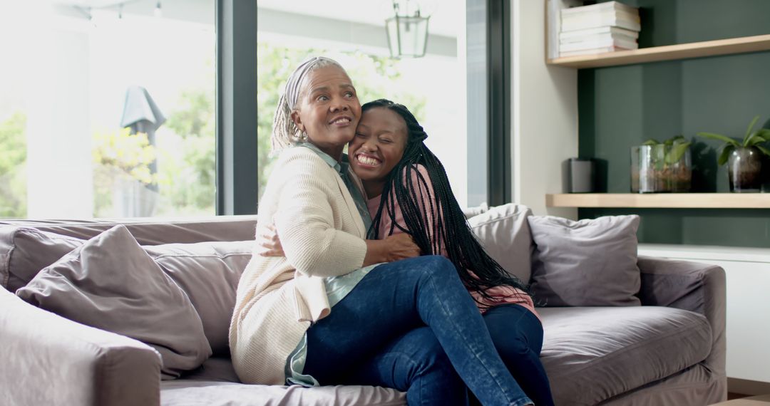 Loving grandmother hugging granddaughter on sofa indoors - Free Images, Stock Photos and Pictures on Pikwizard.com