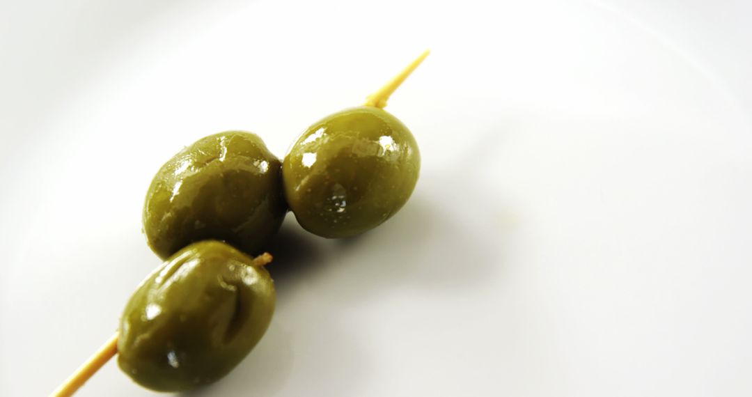 Three Green Olives on Skewer Isolated on White Background - Free Images, Stock Photos and Pictures on Pikwizard.com