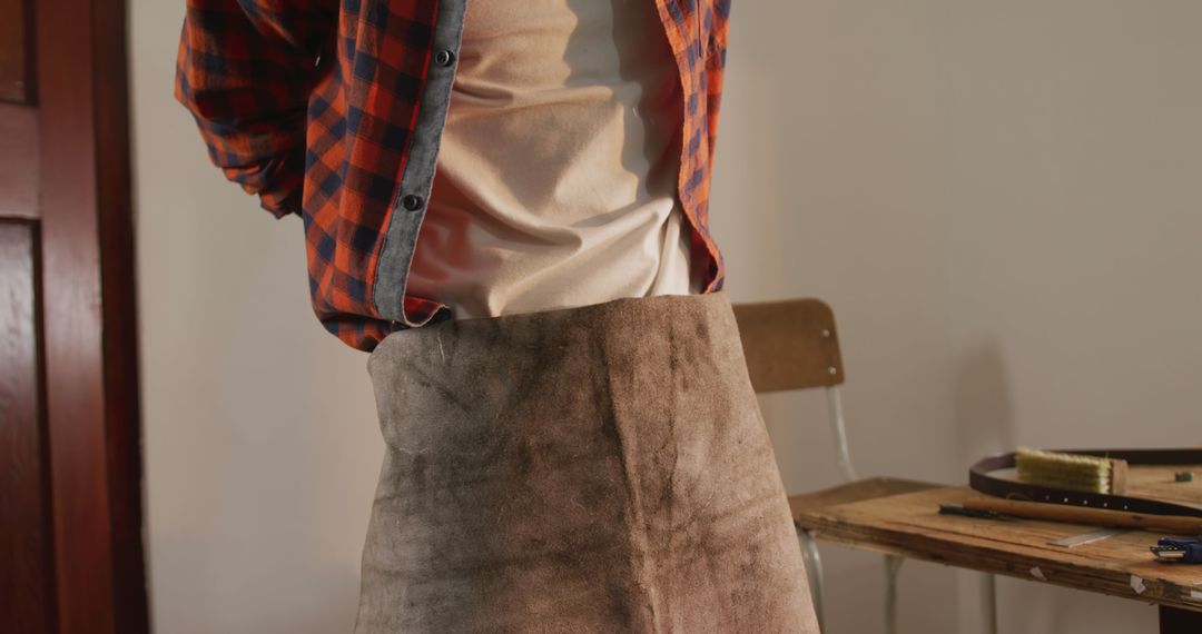 Artisan Wearing Apron in Rustic Leather Workshop