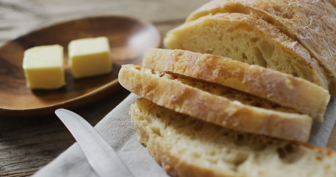 Freshly Baked Bread Slices with Butter on Rustic Table