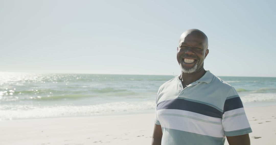 Smiling African American Man Relaxing on Seaside Beach - Free Images, Stock Photos and Pictures on Pikwizard.com