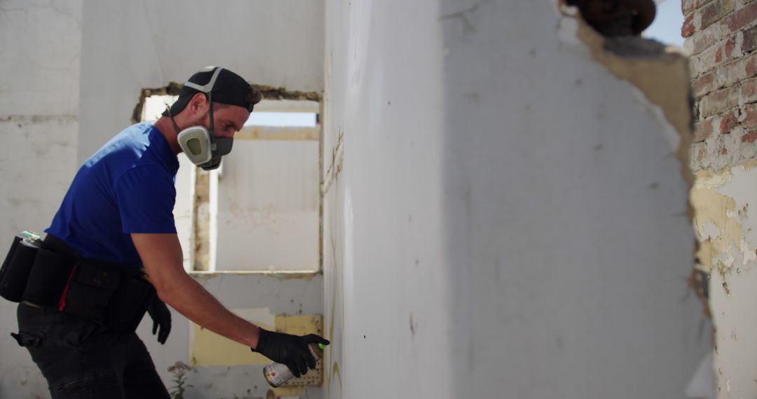 Construction Worker Spray Painting Wall in Abandoned Building - Free Images, Stock Photos and Pictures on Pikwizard.com