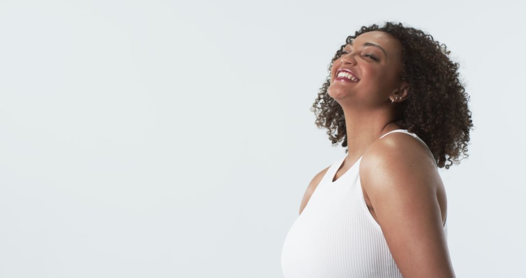 Joyful Plus Size Woman with Curly Hair Smiling Against White