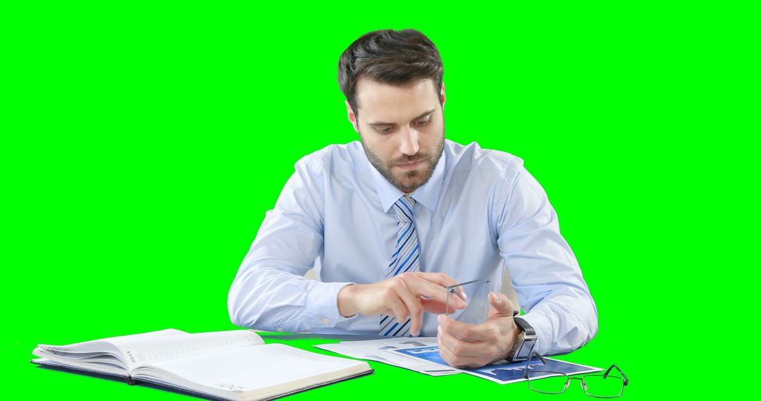 Businessman Holding Pen Analyzing Documents with Open Notebook - Free Images, Stock Photos and Pictures on Pikwizard.com