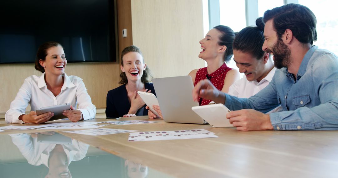 Smiling Business Team in Lively Meeting with Digital Devices