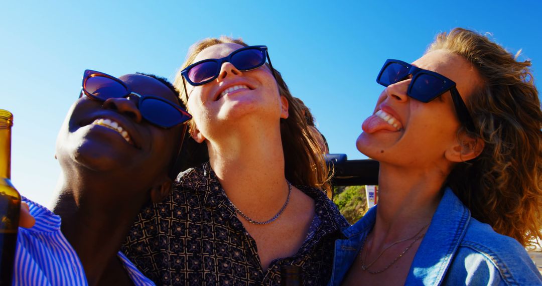 Happy Women Enjoying Sunny Day with Sunglasses at Beach - Free Images, Stock Photos and Pictures on Pikwizard.com