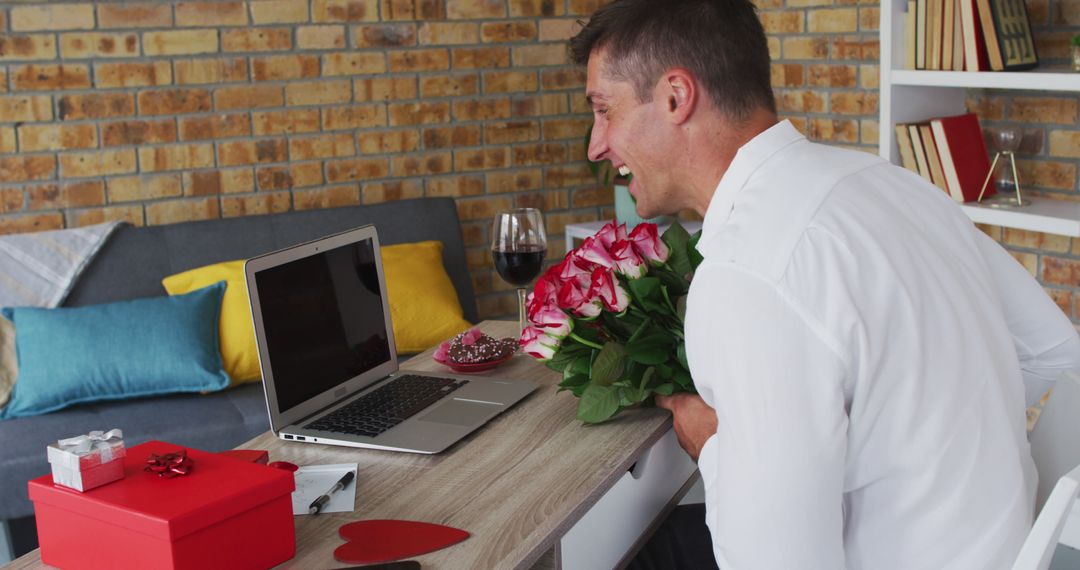 Caucasian man making image call using laptop holding bunch of flowers and blowing kiss - Free Images, Stock Photos and Pictures on Pikwizard.com