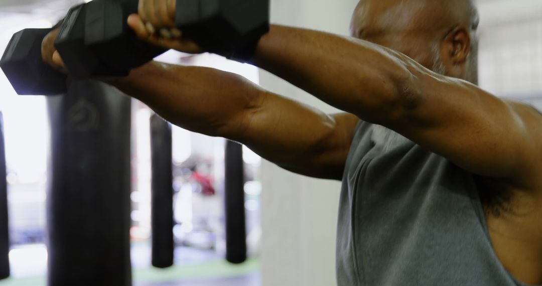 Focused Black Man Lifting Dumbbells in Gym - Free Images, Stock Photos and Pictures on Pikwizard.com