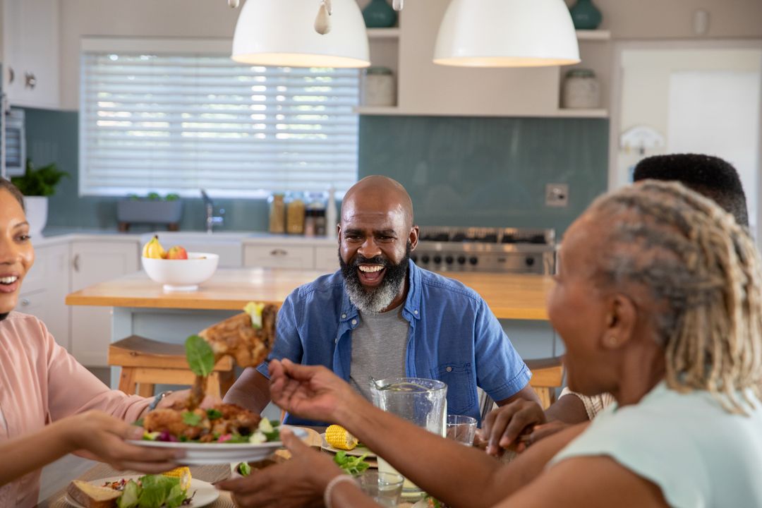 Smiling Multigenerational Family Enjoying Meal Together in Modern Kitchen