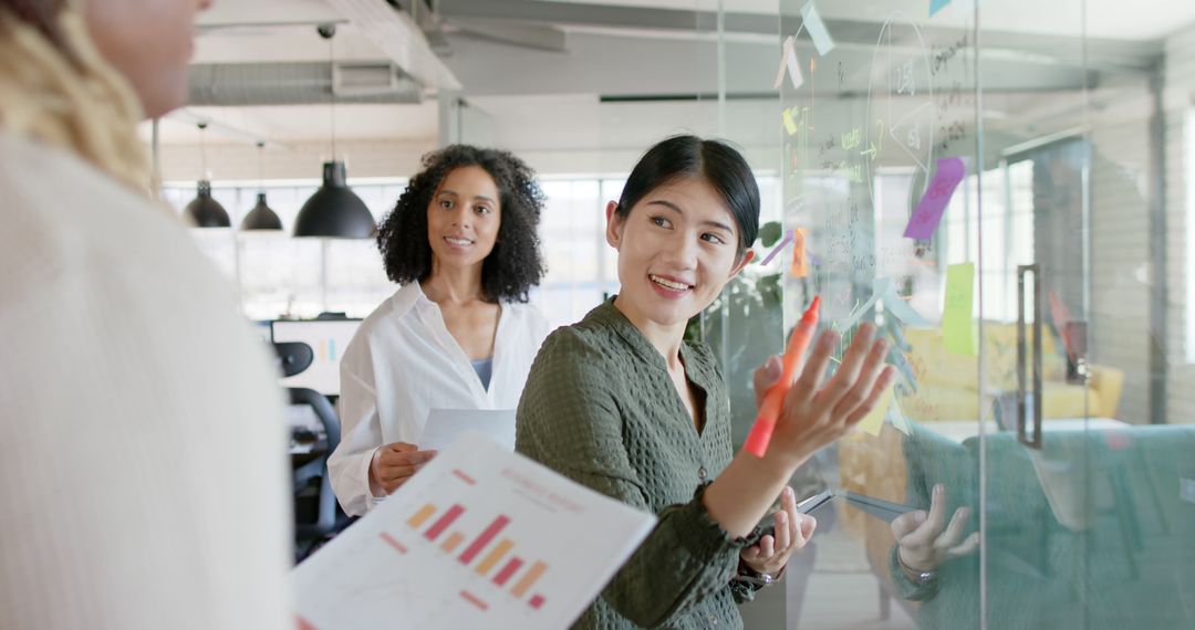 Diverse Team Collaborating at Glass Board in Modern Office